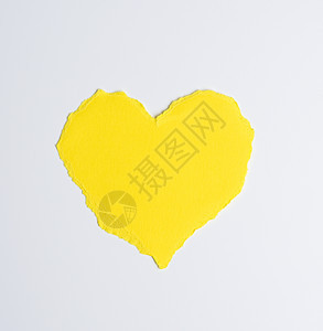 白色背景上的黄色纸做的心胸图片