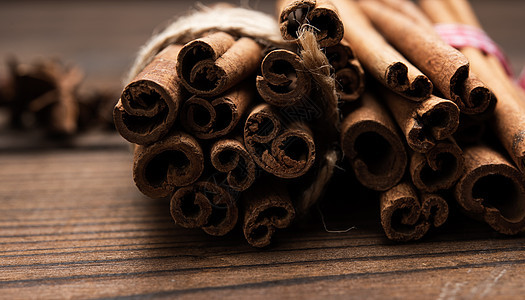 木制背景的棕色肉桂棍子绑起来烹饪木头香料厨房细绳黑色桌子工作室肉桂甜点图片