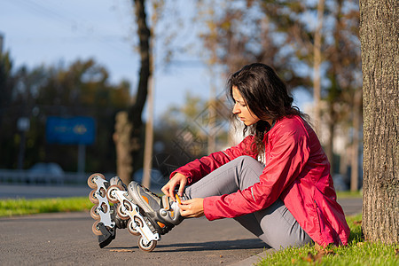 一个运动女孩在秋天的公园里滚滚滚滚滚车轮锻炼女性微笑青少年娱乐街道溜冰者爱好速度图片