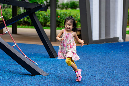 在游乐场上跑跑跑玩耍时 可爱的小女孩跑步裙子场地微笑幸福绿色金发金发女郎女性童年图片