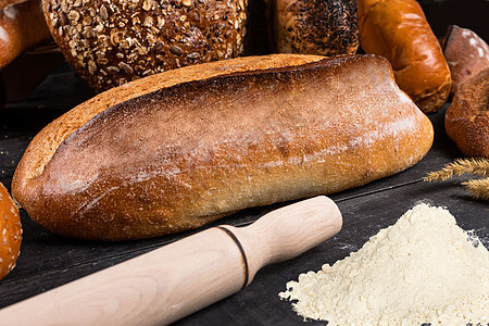 面粉小麦和黑暗背景的谷类面包新鲜鲜面包图片