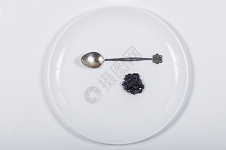 盘子上的勺子和黑鱼子酱螺旋藻 是昂贵的精华 从上面看图片