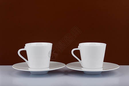 白色桌上两个咖啡杯 棕色背景 有文本空间的两杯咖啡杯图片