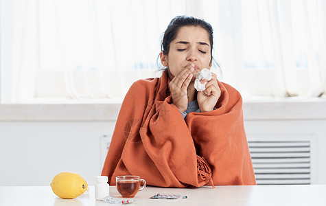 女人拿着一杯茶巾的茶巾 手握着卫生问题 流鼻血维他命疾病玻璃女士组织流感长椅喷嚏感染药品枕头图片