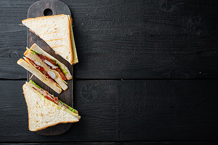 含火腿 奶酪 西红柿 生菜 鸡肉和烤面包的桑威奇三明治 在黑木制桌子上 带有文字复制空间的顶视图图片