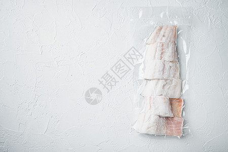 Haddock 塑料市场包装中的白鱼片 以白色背景 带有文本复制空间的顶端视图鳕鱼密封小袋文字真空白鱼海鲜图片