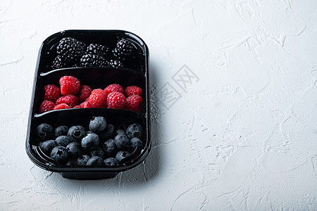 新鲜浆果包装在托盘 蓝莓 草莓和黑莓中 有文字空间 以白色背景图片