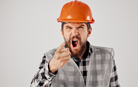 建筑师的手举着手势 戴着橙色硬帽 在浅薄的背景和反射背心上建设者工人工作建筑工作室安全帽职业商业黄色安全图片