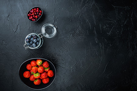 草莓 红莓和蓝莓在碗里 带有文字空间的顶视图 黑色背景图片