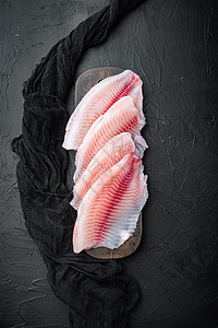 黑底 顶视面的蒂拉皮亚鱼片肉海鲜粉色白鱼图片