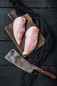 黑木制餐桌顶视角上 用屠宰刀在黑木板上烤鸡胸图片