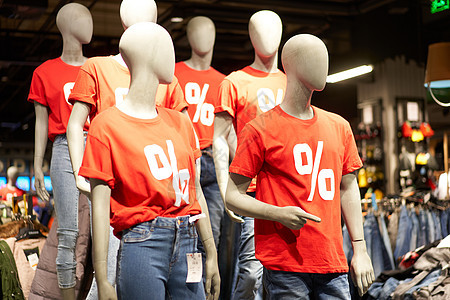 在一个装扮成模特的红色T恤上涂上百分号 印在不专注商店的化妆品摊位上广告陈列柜折扣人体窗户购物中心模型商业市场展示图片
