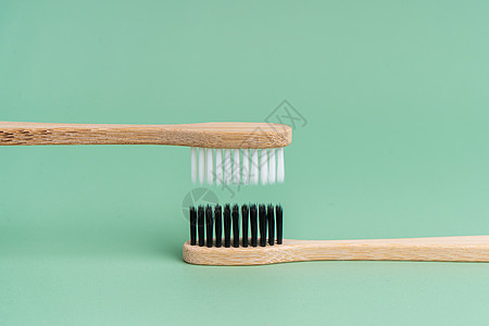 浅绿色背景上有白色和黑色刷毛的两把环保抗菌竹木牙刷 保护环境是趋势 宽容 复制空间生态牙医牙齿纤维生物刷子牙科卫生生活浴室图片