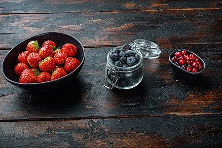 草莓 红莓和蓝莓在碗中 有旧木本文字空间图片