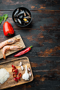 Paella 旧木制黑桌上的海产食品成分 带有文字空间的顶端视图背景对虾海鲜饭小吃食物黑木油炸烹饪桌子乡村图片
