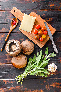 波塔贝罗蘑菇成分 用于烘烤 干酪奶酪 樱桃西红柿和白薯 在旧的黑桌子上 顶层风景图片