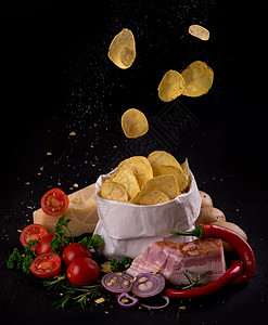 黑木板上的马铃薯片 快餐 黑暗背景食物营养垃圾芯片篮子土豆乡村育肥油炸筹码图片
