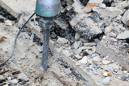 男性工人使用电动混凝土破碎机在当地城市道路 人行道 工作施工现场用手提钻挖掘和钻孔混凝土修复车道表面技术岩石工程铺路建设者破坏建图片