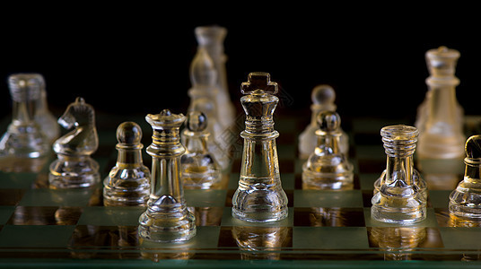 玻璃象棋碎片在黑暗中保护着国王的天上主教蓝色战略头脑闲暇反射场地城堡木板力量图片