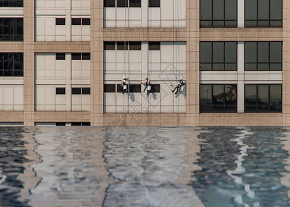 一群工人在高楼办公大楼打扫窗户服务 并配有反射纤维泳池玻璃团体风险涟漪游泳池垫圈场景男人安全建筑学图片