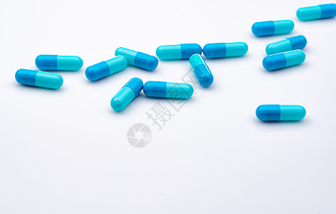 在白色背景上传播的蓝色胶囊药丸 医药行业 医疗保健和医学概念 卫生预算 处方类药物 药物错误概念 医药产品 药剂学图片