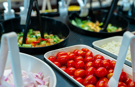 餐厅的沙拉吧自助餐 午餐或晚餐供应新鲜沙拉吧自助餐 健康食品 选择性地关注柜台上白碗里的红番茄 餐饮食品 宴会服务 素食图片