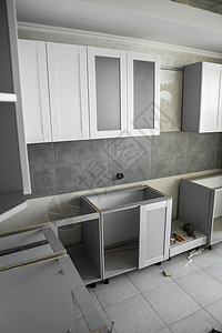 带有家具外墙 mdf 的定制厨柜安装 灰色模块化厨房由刨花板材料制成 处于不同的安装阶段 框架家具正面是 mdf 型材硬木组装家图片