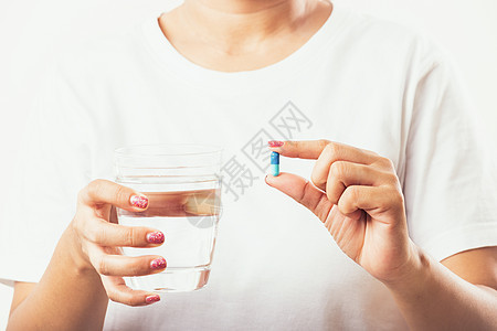 妇女手持避孕药 准备就绪 用一杯水来服药药物保健药店疼痛福利玻璃女孩压力卫生偏头痛图片