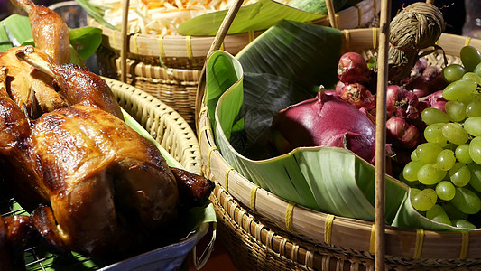 装有烤鸡和水果的篮子 在传统的泰国街头餐馆 摊位上摆着带美味炸鸡和新鲜水果的编织篮子图片