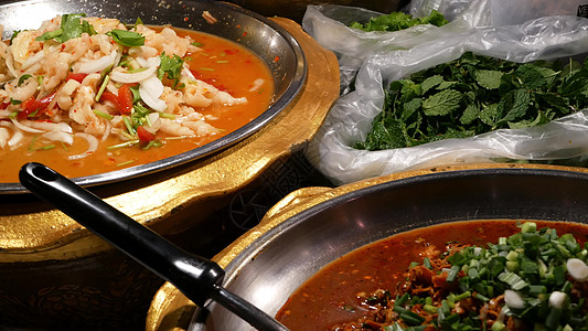 摊位上放着各种亚洲菜肴的碗 晚上 街头小餐馆的摊位上摆着一碗碗各式