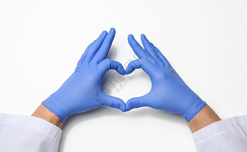 两只男性手用蓝色的乳胶不消毒 医疗手套显示心脏在白色背景上的姿势图片
