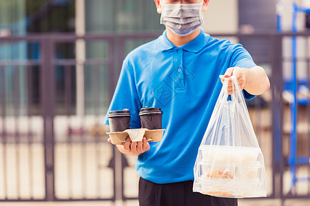 身戴面罩的分娩男子在前屋做杂货 提供大米食品盒 塑料袋和咖啡塑料邮递员命令送货工作商业口罩杯子工人船运图片