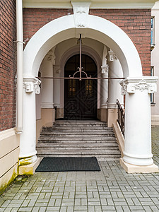 建筑物入口处有楼梯和门的混凝土拱门图片