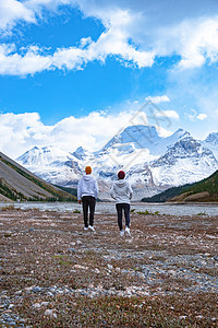 在加拿大艾伯塔班夫国家公园附近的加拿大洛基斯 有雪山的男子和女子徒步旅行女孩雨衣远足冒险成人男人男性自由海滩山脉图片