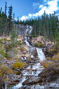 加拿大艾伯塔省贾斯珀国家公园的瀑布 一对中年男女徒步前往大自然中的瀑布大路风景山脉旅游公园国家冰川溪流森林女孩图片