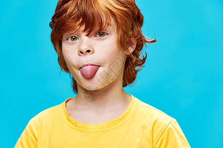 红发男孩的口舌紧近黄色T恤滑稽图片