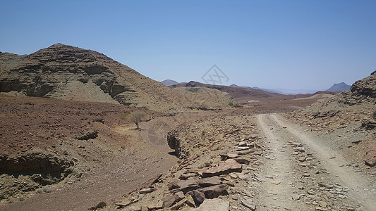 穿过沙漠的碎石路爬坡石头公路岩石天空图片