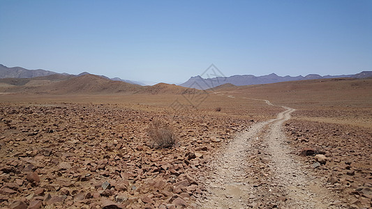 沙漠石头穿过沙漠的碎石路公路岩石天空石头爬坡背景