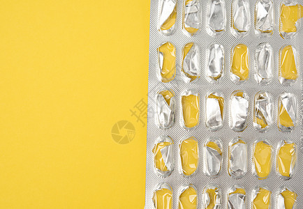 黄色背景的空白胶囊药丸充气袋水疱止痛药制药药品医疗挫败治疗药剂塑料药店背景图片