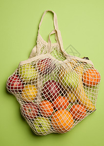 绿色背景的纺织绳袋中熟熟新鲜果实图片