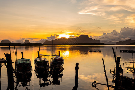 以及泰国巨大的石灰岩山后出现的多彩的日出和日出 在泰国旅游橙子阳光钓鱼海景太阳渔夫蓝色假期天空图片