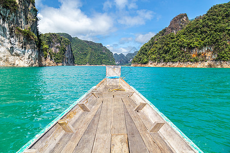 在或Khao Sok国家公园的湖上有山脉的泰国传统长尾拖船风景天空场景岩石公园森林国家闲暇旅行丛林图片