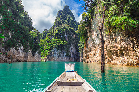 在或Khao Sok国家公园的湖上有山脉的泰国传统长尾拖船风景假期局域网蓝色岩石森林公园旅游热带娱乐图片
