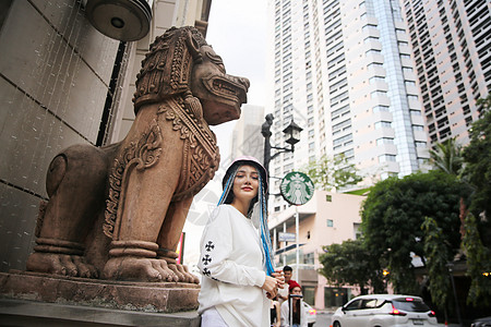 穿着长蓝色头发的粉红色夹克 戴帽子在街上 在城市街道上皮肤女士快乐青年成人发型幸福女性喜悦女孩背景图片