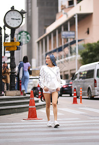 穿着长蓝色头发的粉红色夹克 戴帽子在街上 在城市街道上幸福皮肤发型女性喜悦享受青年冒充成人快乐背景图片