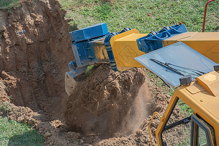 巴克特挖土机在地上挖坑图片