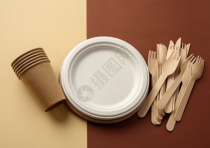 纸杯和木叉 用棕色背景的回收材料制成的空圆形棕色可支配板空白盘子厨房野餐浪费包装牛皮纸食物餐具竹子图片