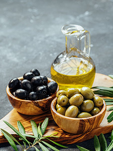 不同类型橄榄和橄榄油的一套叶子蔬菜木头团体绿色砧板黑色瓶子木板背景图片