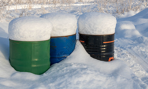 雪中冷冻皱巴巴的红桶阳光环境资源金属工厂蓝色技术燃料材料制造业图片