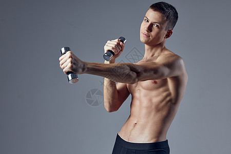 运动男子在锻炼健身时夸大了躯干哑铃图片